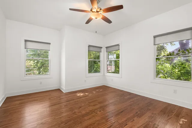 a view of room with window ceiling fan and hardwood floor