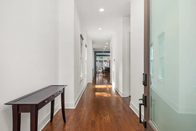 a view of a hallway with wooden floor and staircase