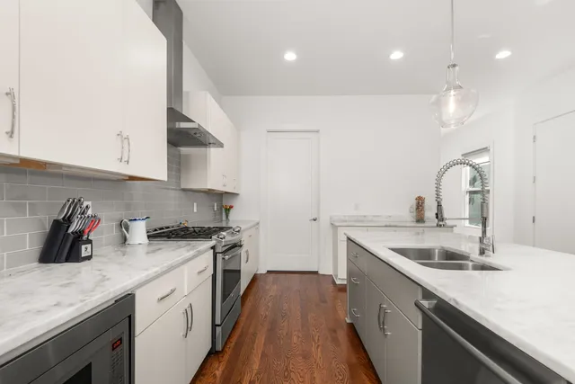 a kitchen with a sink a stove and cabinets