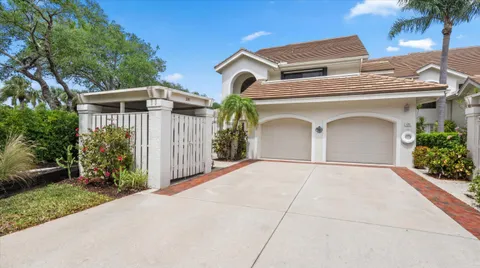 a view of a house with a yard and potted plants