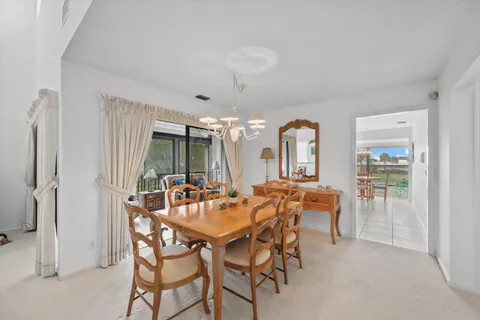 a kitchen with stainless steel appliances granite countertop a stove top oven a sink a dining table and chairs with the view of kitchen