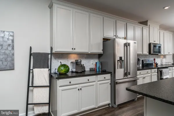 a kitchen with stainless steel appliances white cabinets and a refrigerator