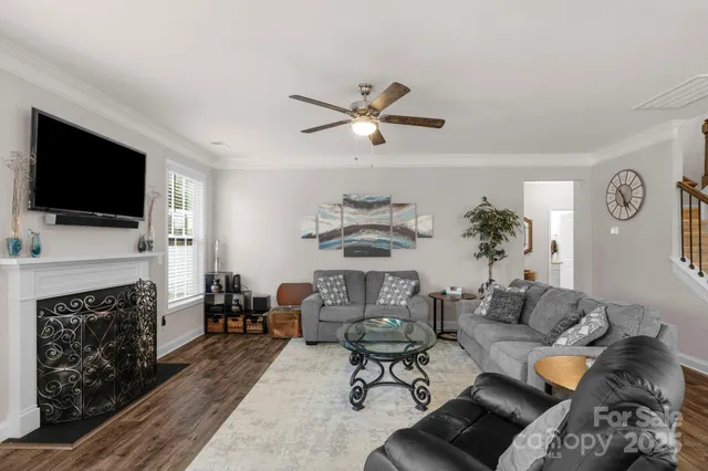 a living room with furniture a fireplace and a flat screen tv