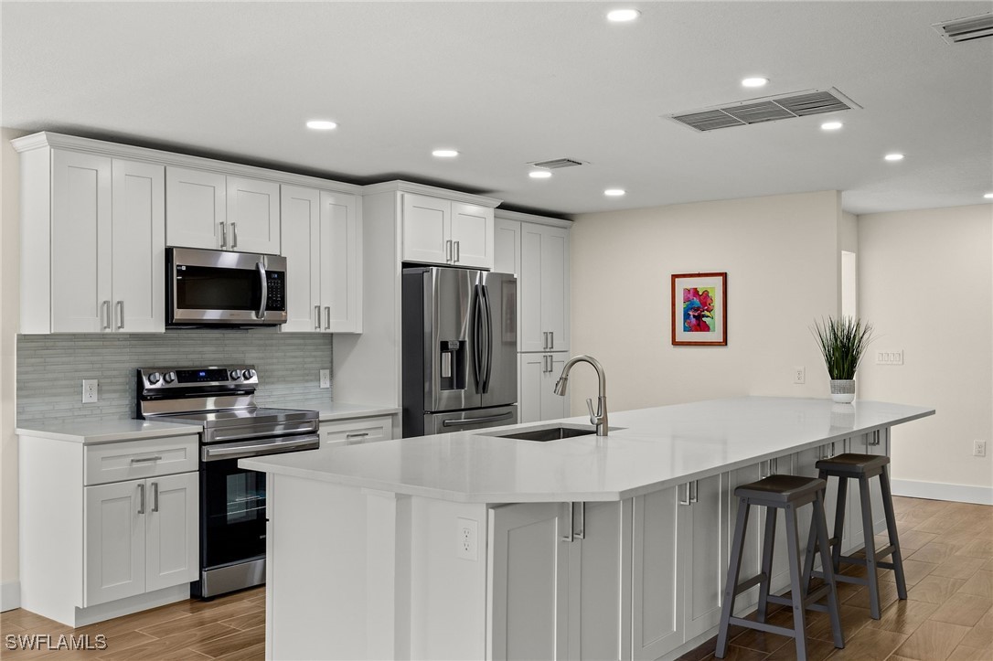 5869 Pine Tree Drive Sanibel, FL 33957 - Photo 15 of 30 a kitchen with kitchen island a appliances dining table and chairs