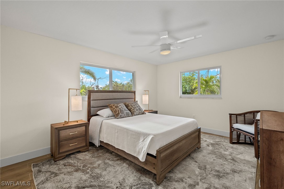 5869 Pine Tree Drive Sanibel, FL 33957 - Photo 19 of 30 a bedroom with a bed and a window