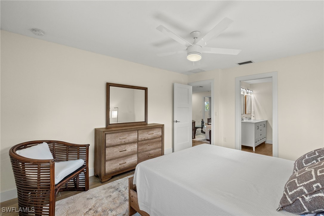5869 Pine Tree Drive Sanibel, FL 33957 - Photo 20 of 30 a bedroom with a bed and wooden floor