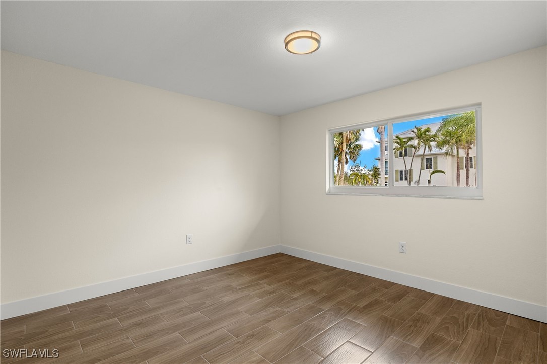 5869 Pine Tree Drive Sanibel, FL 33957 - Photo 23 of 30 an empty room with painting on the wall and a window
