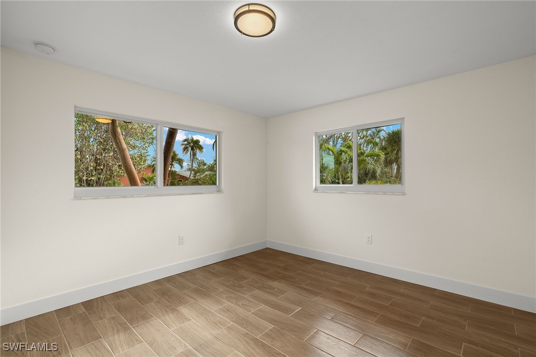 5869 Pine Tree Drive Sanibel, FL 33957 - Photo 25 of 30 an empty room with wooden floor and window