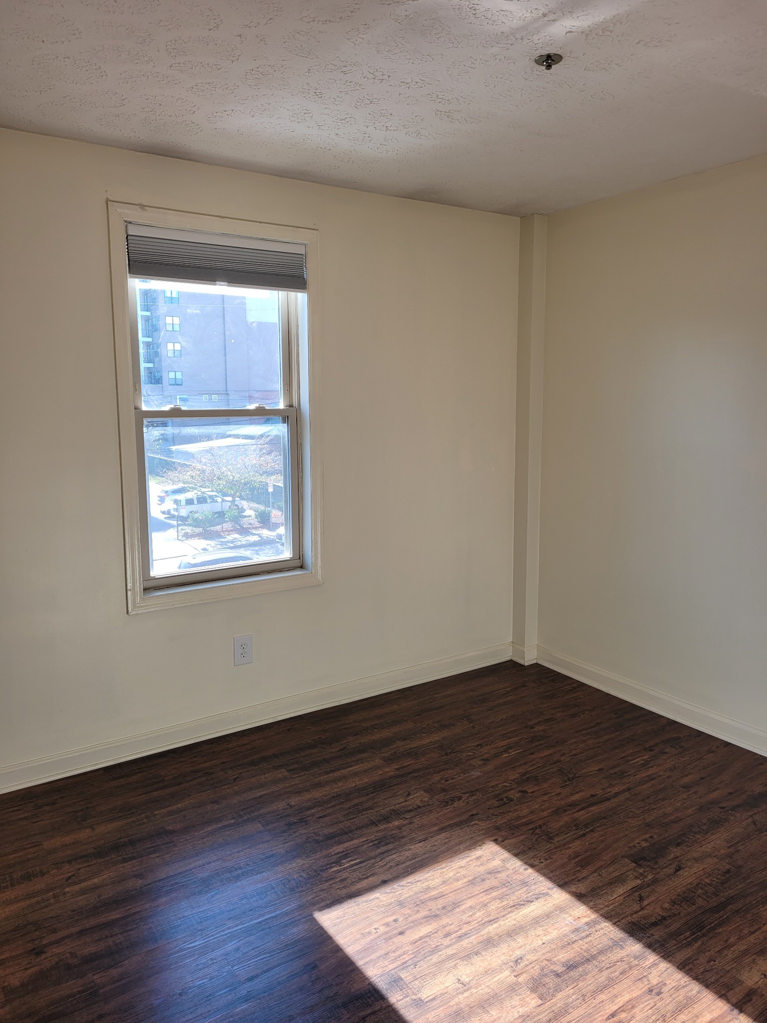 1808 State Street, Unit 307 Nashville, TN 37203 - Photo 6 of 8 a view of an empty room with wooden floor and a window