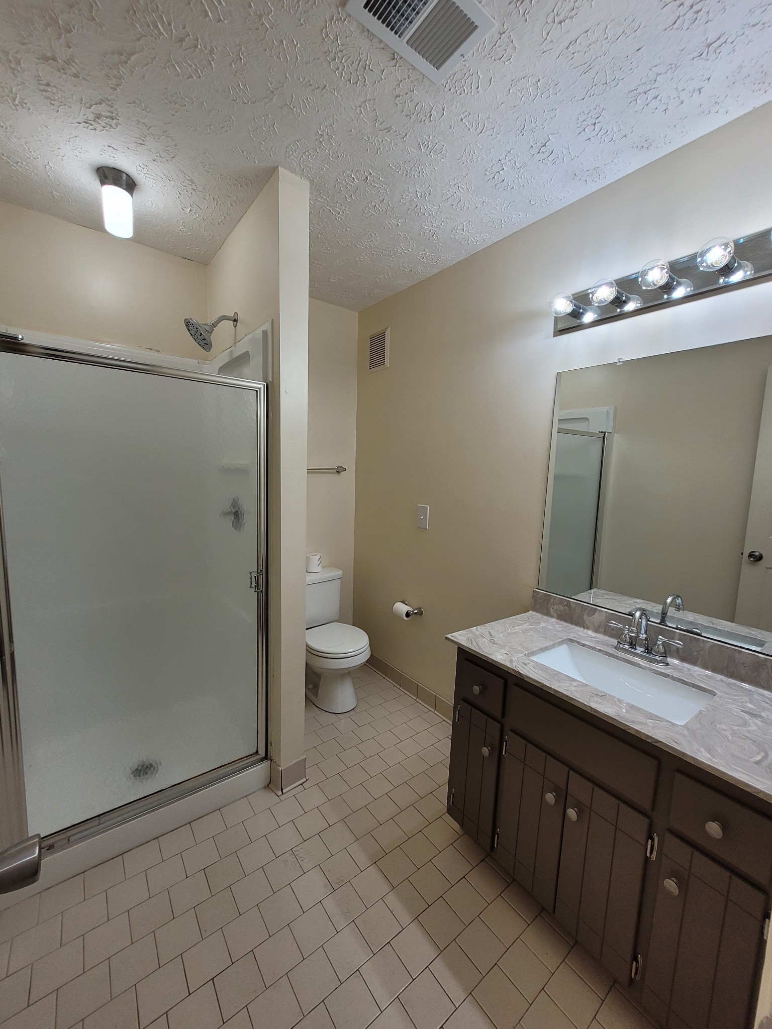1808 State Street, Unit 307 Nashville, TN 37203 - Photo 7 of 8 a spacious bathroom with a granite countertop sink a toilet and a mirror