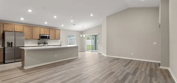 a large kitchen with stainless steel appliances a large counter top and a stove top oven