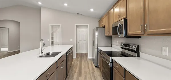 a kitchen with stainless steel appliances granite countertop a sink stove and refrigerator