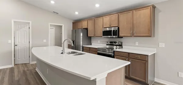 a kitchen with kitchen island a sink appliances and cabinets