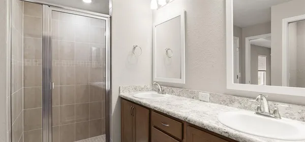 a bathroom with a granite countertop sink a mirror and a shower