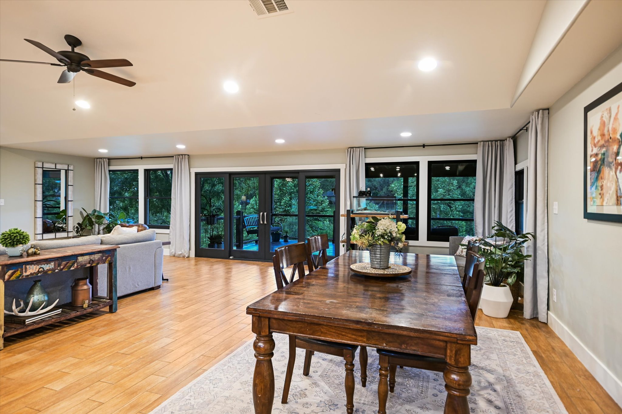 2411 Spoke Hollow Road Wimberley, TX 78676 - Photo 8 of 37 Hardwood floors and generous windows showcase tree-lined views throughout this spacious gathering area.