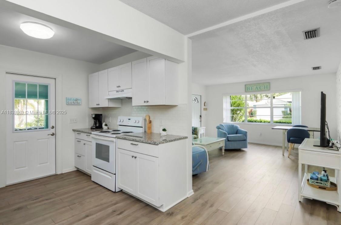 1115 Hernando Street, Unit A Fort Pierce, FL 34949 - Photo 12 of 18 a kitchen with stainless steel appliances white cabinets and wooden floor