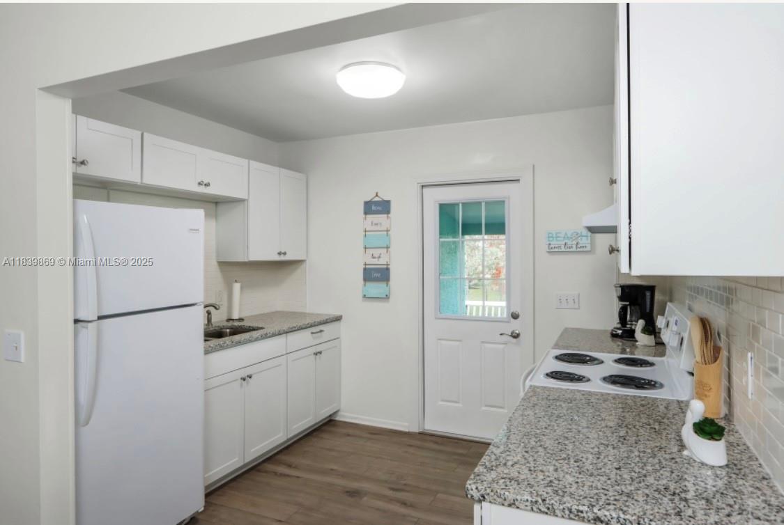 1115 Hernando Street, Unit A Fort Pierce, FL 34949 - Photo 13 of 18 a kitchen with a refrigerator a stove and white cabinets