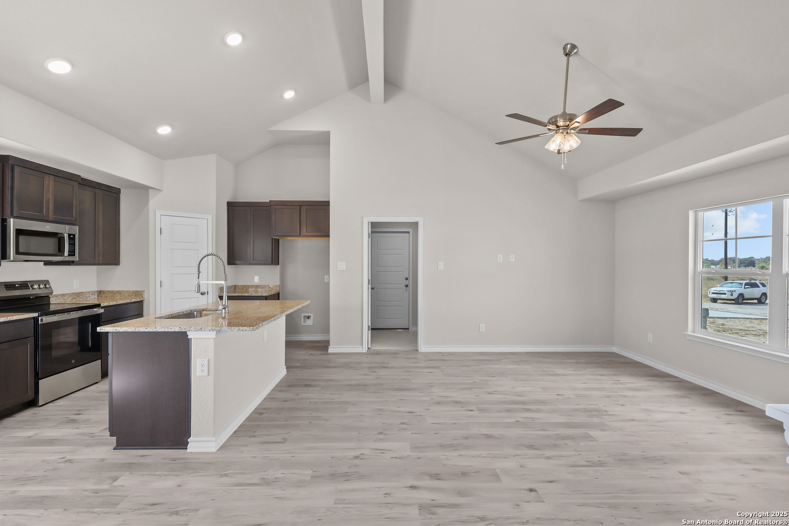 30 Log Cabin Way Poteet, TX 78065 - Photo 12 of 47 a large white kitchen with a refrigerator stove a sink dishwasher and white cabinets with wooden floor