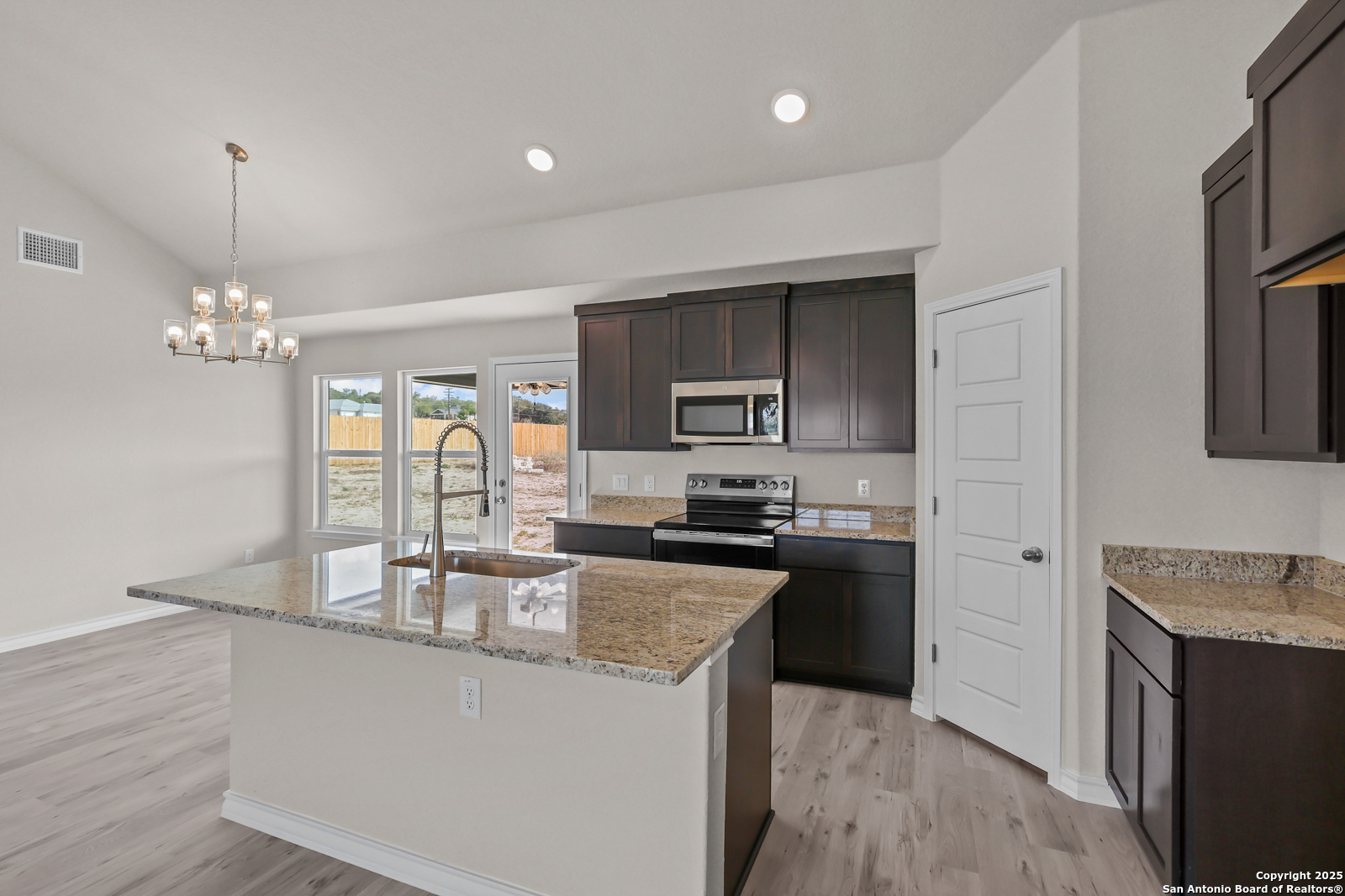 30 Log Cabin Way Poteet, TX 78065 - Photo 15 of 47 a kitchen with stainless steel appliances granite countertop a sink a stove top oven a counter space and cabinets