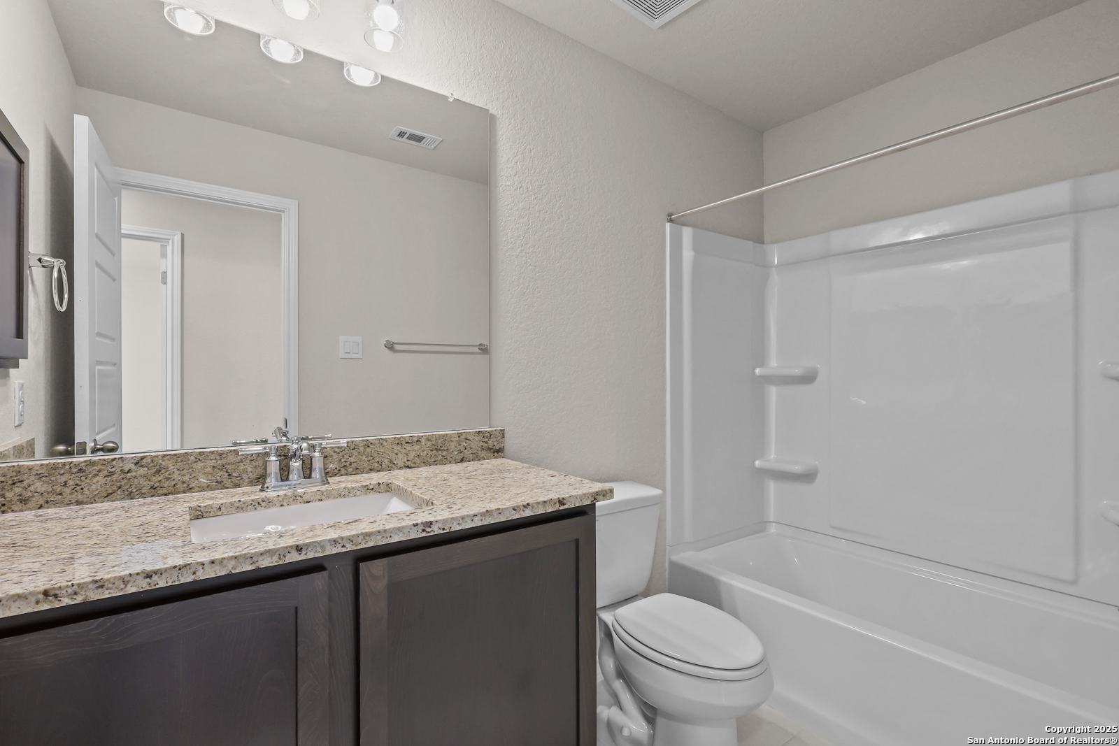 30 Log Cabin Way Poteet, TX 78065 - Photo 30 of 47 a bathroom with a granite countertop sink a toilet and shower