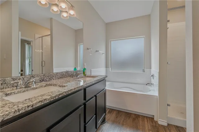 a bathroom with a granite countertop sink a large mirror and a bathtub