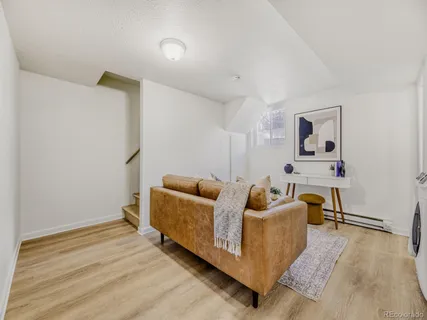 a living room with furniture and a wooden floor
