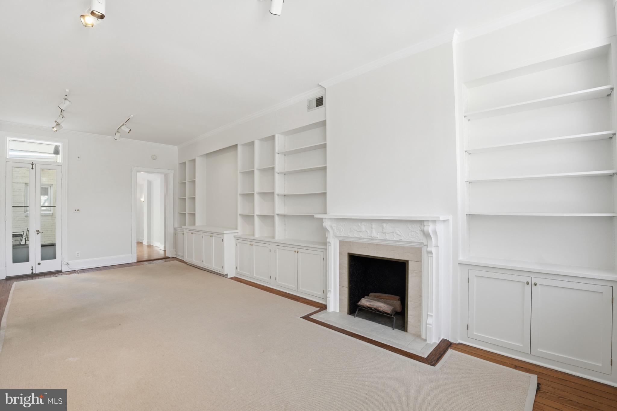 1635 35th Street Northwest Washington, DC 20007 - Photo 5 of 27 a view of an empty room with a fireplace and a window
