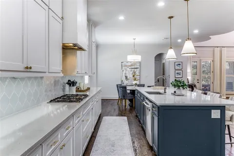 a kitchen with stainless steel appliances a sink stove and cabinets