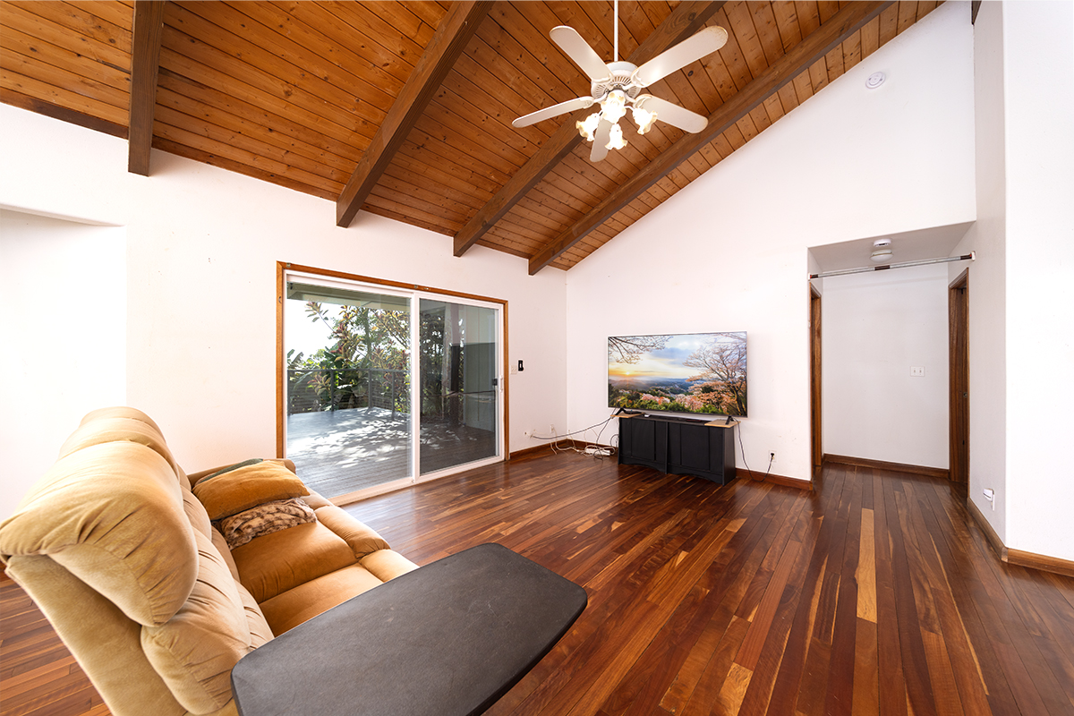 25-3301 Pakelekia Street Hilo, HI 96720 - Photo 13 of 30 a living room with furniture floor to ceiling window and wooden floor