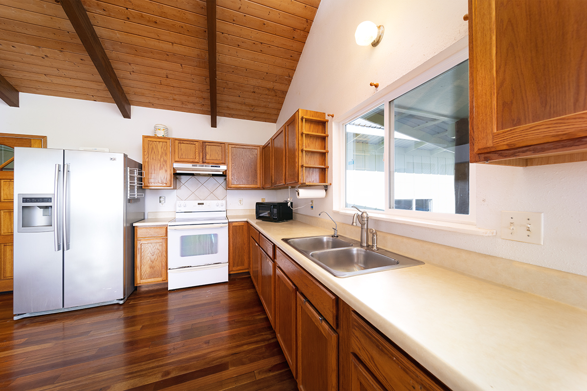 25-3301 Pakelekia Street Hilo, HI 96720 - Photo 17 of 30 a kitchen with stainless steel appliances granite countertop a sink a stove and a refrigerator