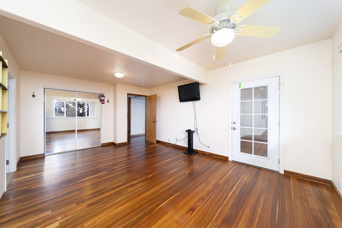 25-3301 Pakelekia Street Hilo, HI 96720 - Photo 20 of 30 a view of an empty room with wooden floor and a ceiling fan