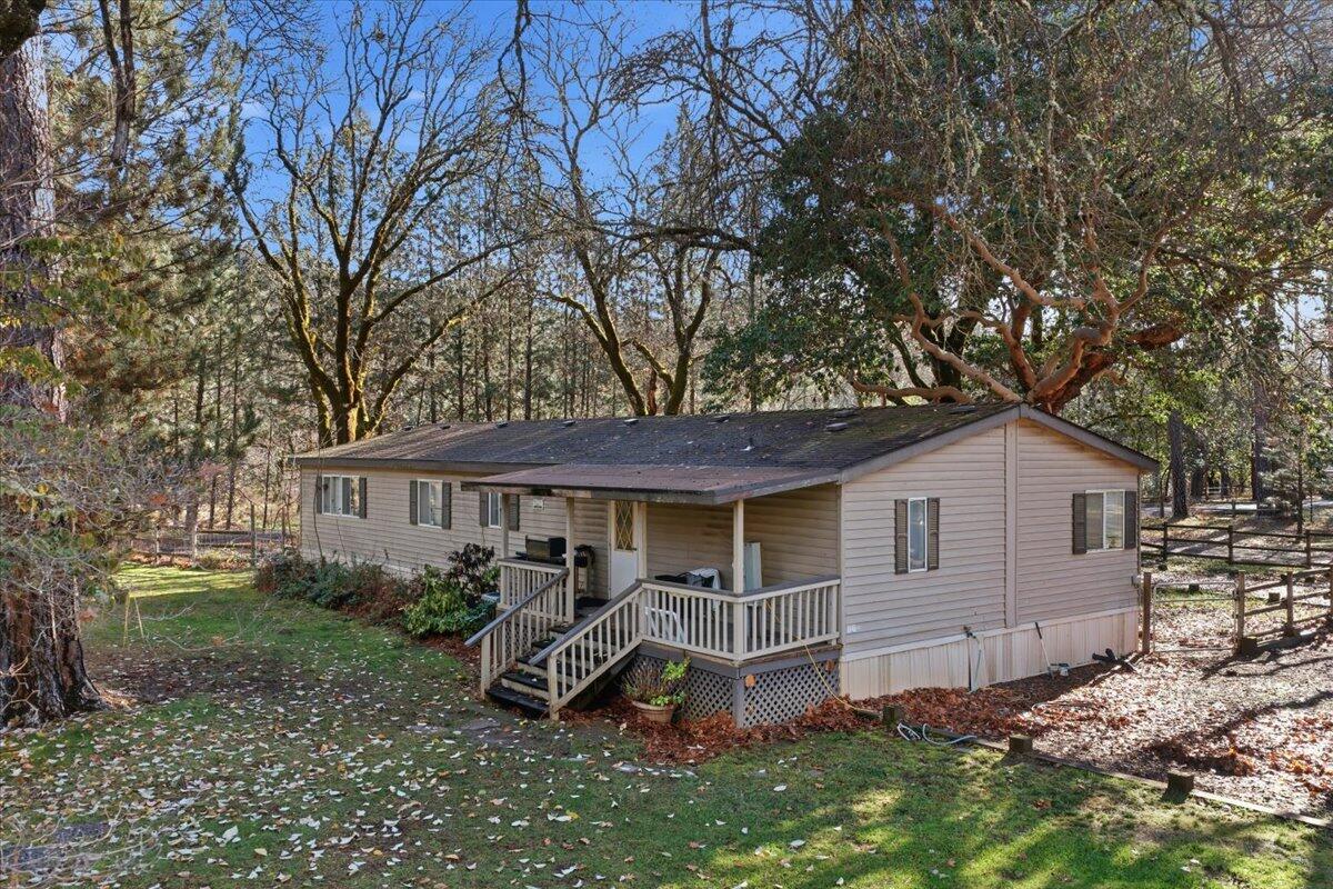 1401 Upper River Road Gold Hill, OR 97525 - Photo 1 of 8 a view of a house with a yard and large tree