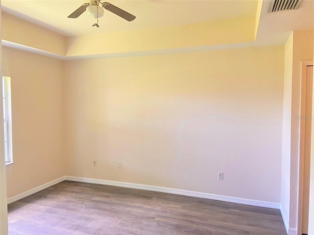 5771 Sabal Trace Drive, Unit 102 B5771 North Port, FL 34287 - Photo 14 of 37 an empty room with a ceiling fan and wooden floor