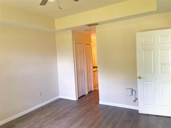 an empty room with wooden floor and closet
