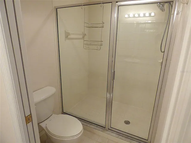 a white toilet sitting next to a shower