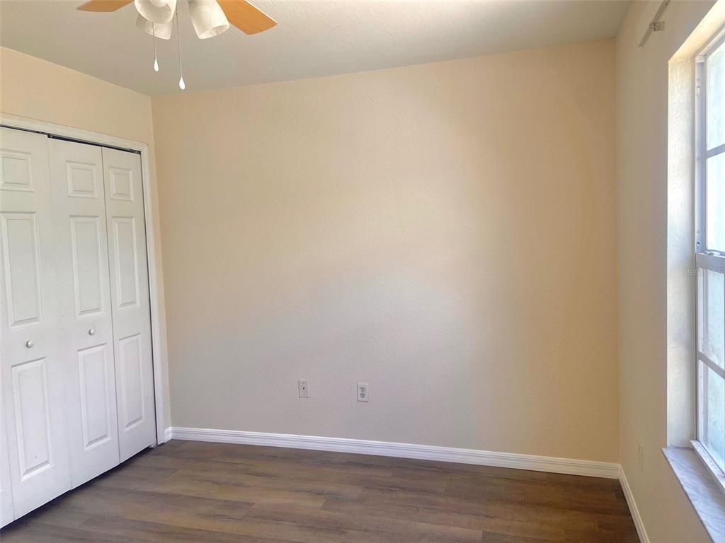 5771 Sabal Trace Drive, Unit 102 B5771 North Port, FL 34287 - Photo 28 of 37 a view of an empty room with wooden floor and a window