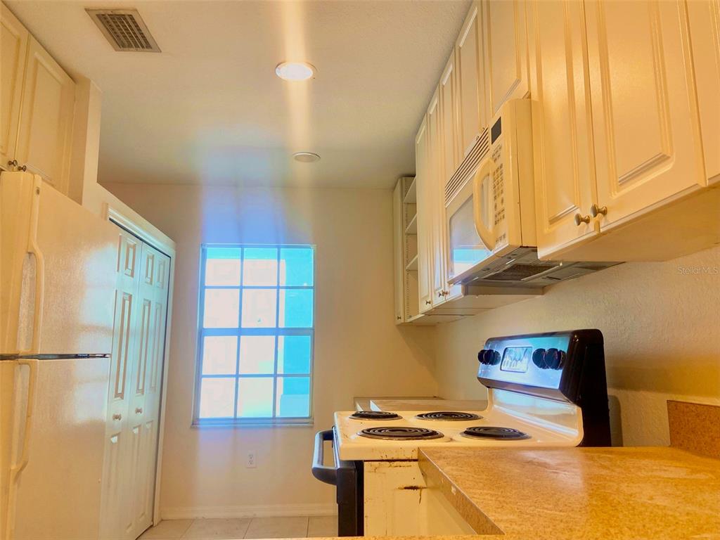 5771 Sabal Trace Drive, Unit 102 B5771 North Port, FL 34287 - Photo 4 of 37 a kitchen with stainless steel appliances granite countertop a refrigerator and a stove