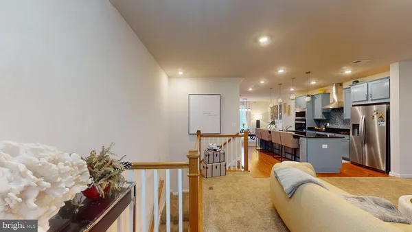 a living room with furniture kitchen area and a refrigerator