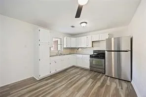 a view of a room with wooden floor and a ceiling fan