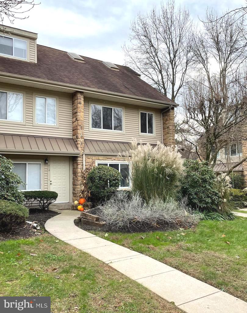 214 Carriage Court, Unit 214 Chesterbrook, PA 19087 - Photo 2 of 41 a front view of a house with a yard and potted plants