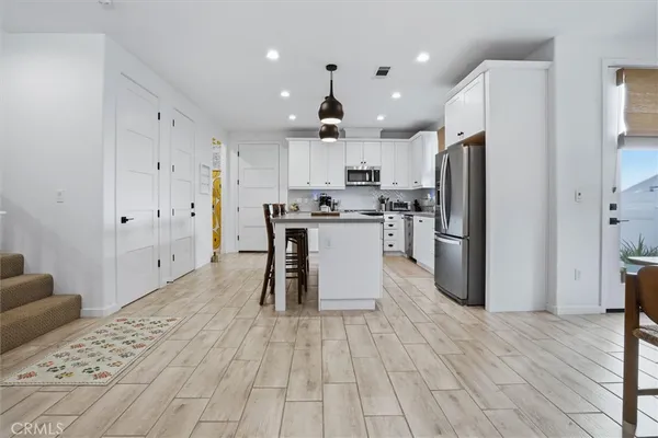 a kitchen with stainless steel appliances kitchen island granite countertop a refrigerator and a stove top oven