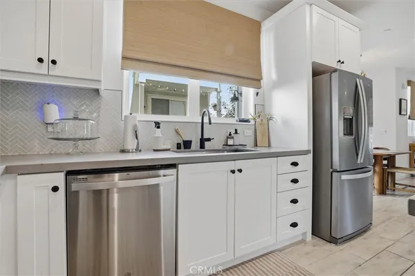 a kitchen with stainless steel appliances granite countertop a sink and a refrigerator