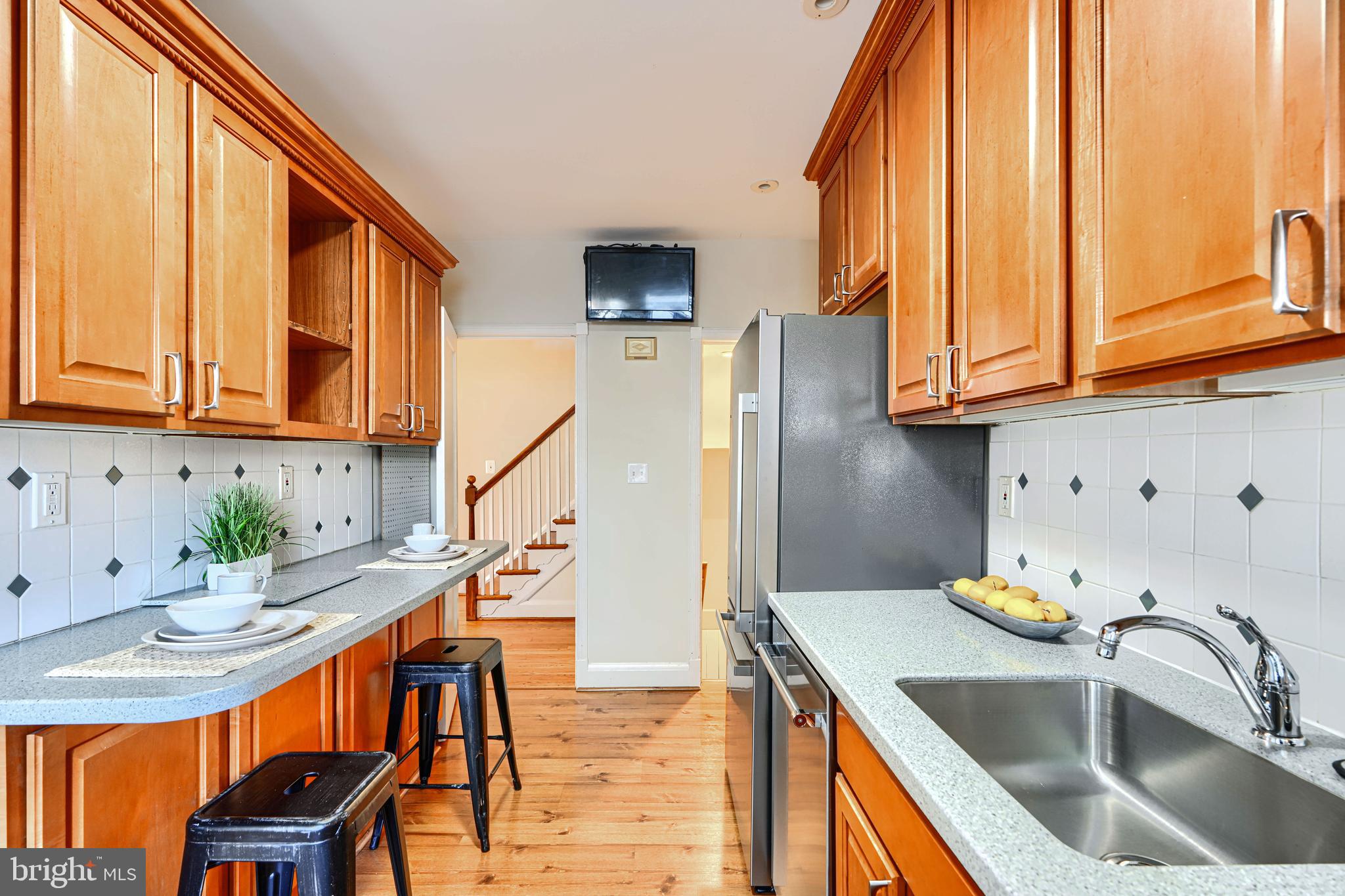 100 Dunkirk Road Baltimore, MD 21212 - Photo 16 of 65 a kitchen with stainless steel appliances granite countertop a sink a refrigerator and wooden cabinets