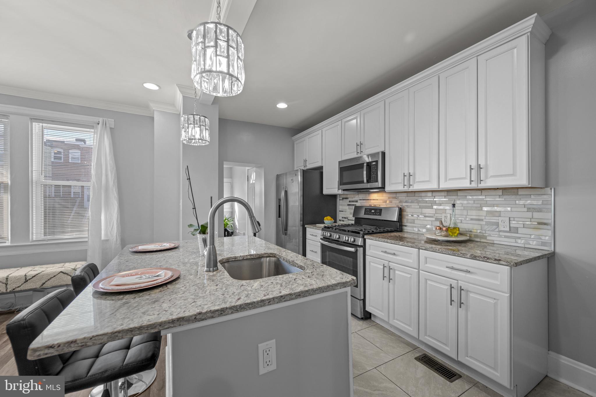 3009 Kentucky Avenue Baltimore, MD 21213 - Photo 13 of 42 a kitchen with stainless steel appliances granite countertop a sink dishwasher stove and white cabinets with wooden floor