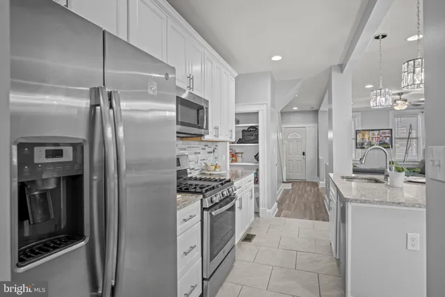 a kitchen with stainless steel appliances granite countertop a refrigerator and a stove