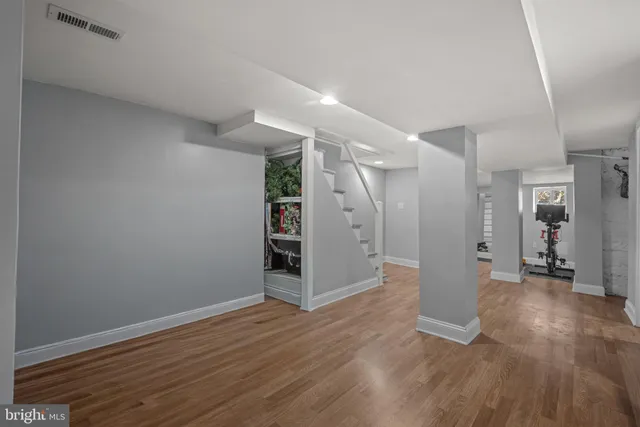 a view of a big room with wooden floor and windows