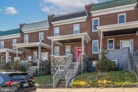 a view of a brick house with many windows and a table and chairs
