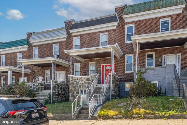 a view of a brick house with many windows and a table and chairs