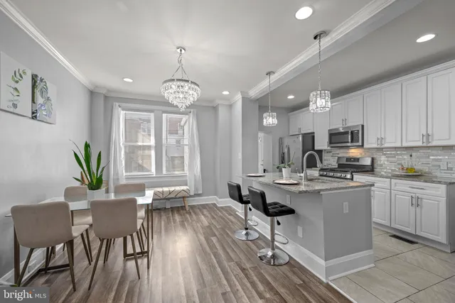 a living room with stainless steel appliances kitchen island granite countertop furniture wooden floor and a view of kitchen