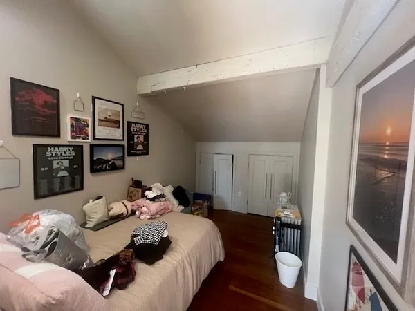 a bedroom with bed and wooden floor